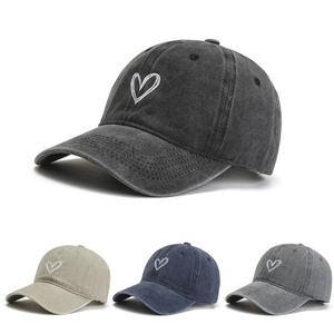 Detail of embroidered heart on washed cotton baseball cap available in four colors