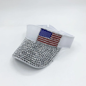 Detailed view of silver rhinestones and American flag patch on white sun visor cap