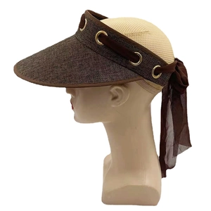 Detail of dark brown straw visor with gold eyelets and elegant chiffon ribbon tie