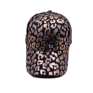 Front view of stylish baseball cap with rose gold leopard print on navy blue fabric