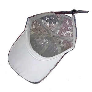 Détail de la casquette baseball en dentelle florale avec boucle métal et texture mauve