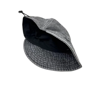 Detail of grey washed denim bucket hat showing adjustable elastic drawstring and inner lining