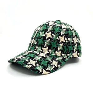 Detail of green and white houndstooth textured fabric on a warm winter baseball cap