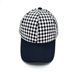 Front view of a black and white houndstooth patchwork baseball cap with a solid black brim