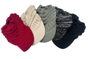 Detail showing various colors of thick knit winter hats with brims and pom-poms