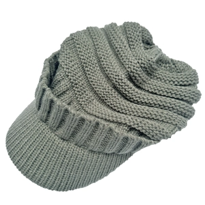 Detail of grey knitted beanie with visor showing chunky ribbed texture and warm fabric