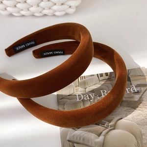 Detail of handmade velvet headbands in brown and caramel with premium craft labels