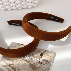 Detailed close-up of brown velvet padded headbands with hand made woven labels