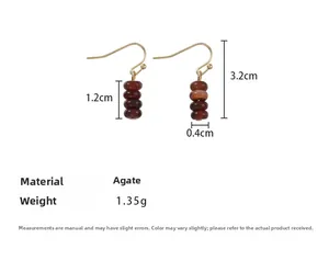 Detailed view of tiger eye agate beaded drop earrings with golden metal hooks