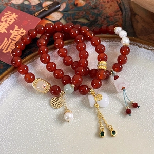 Vue détaillée macro de bracelets vintage en agate et perles avec breloques dorées Fu
