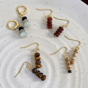 Vintage natural tiger eye stone beaded earrings with gold plated hooks on ceramic tray