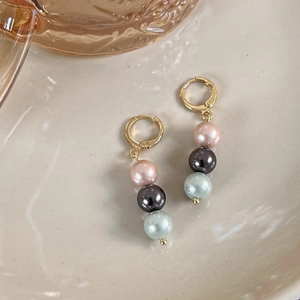 Vue détaillée de boucles d'oreilles dorées avec perles dégradées roses, grises et vertes