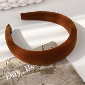 Detail of caramel brown velvet headband with padded structure on a white surface