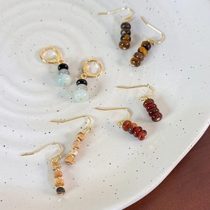 Vintage tiger eye bead earrings set with gold hooks and hoops on a ceramic tray