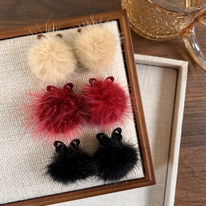 Hollow butterfly earrings with plush fur balls in beige, dark red, and black colors