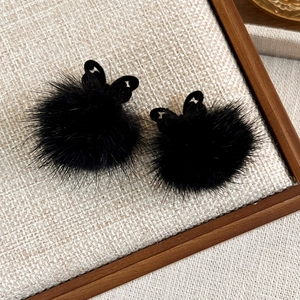 Close-up of black fuzzy butterfly earrings featuring premium faux fur and hollow metal detail