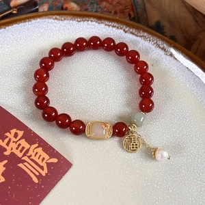 Gros plan du bracelet en perles d'agate vintage avec pendentif doré et perle d'eau douce