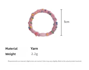 Detailed view of pink yarn hair tie with colorful pompoms measuring 5cm in diameter