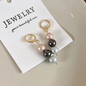 Détail de boucles d'oreilles perles dégradées avec crochets dorés sur carte