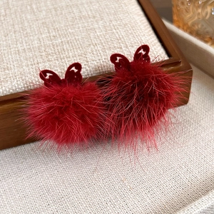 Detailed view of red hollow butterfly studs with fluffy plush balls for autumn and winter