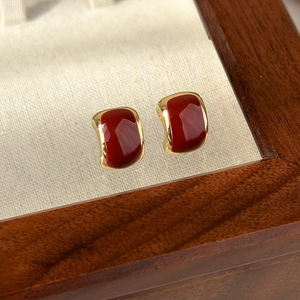 Detailed macro view of vintage red enamel heart geometric earrings with gold trim edges