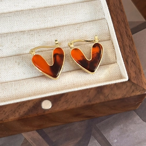 Detail of vintage heart-shaped gold earrings with amber resin in a jewelry box