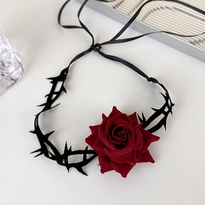 Detail of dark red velvet rose choker with black thorn design and ribbon closure