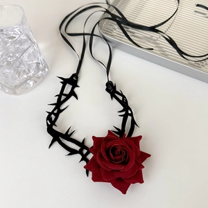 Close-up of gothic dark red velvet rose choker with black thorny branch accents