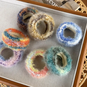 Chouchous en mohair colorés aux teintes Morandi présentés sur un plateau chic