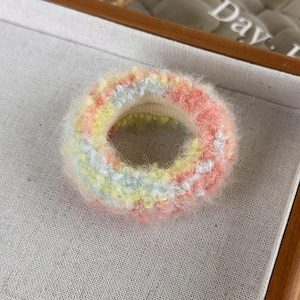 Détail macro d'un chouchou en tricot pelucheux arc-en-ciel avec texture en mohair