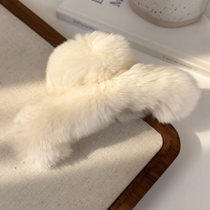 Detail view of large cream plush hair claw clip with soft faux rabbit fur texture