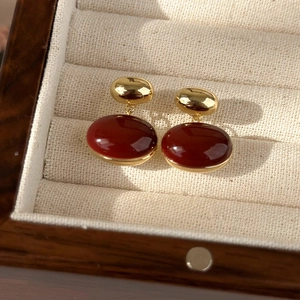 Detailed view of vintage dark red enamel oval earrings with elegant gold metal setting