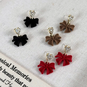 Detailed view of heart rhinestone studs with velvet bows in red, black, and brown