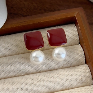 Close-up of vintage heart earrings with deep red enamel and round white pearls