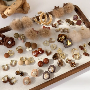 Collezione di orecchini geometrici marroni stile vintage su vassoio di velluto