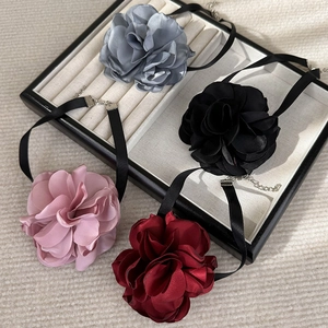 Detailed macro view of satin rose chokers in grey, black, pink, and burgundy fabric