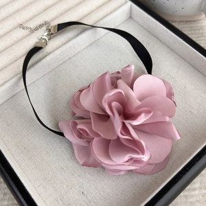 Close-up of pink satin rose choker with black ribbon and metallic lobster clasp