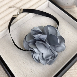 Detail of grey satin flower choker with adjustable silver metal clasp in a jewelry box
