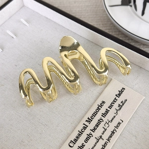 Makroaufnahme der goldenen Wellen-Haarklammer aus Metall in einer Schmuckschatulle