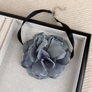 Detail of grey satin rose choker with black silk ribbon in a jewelry gift box