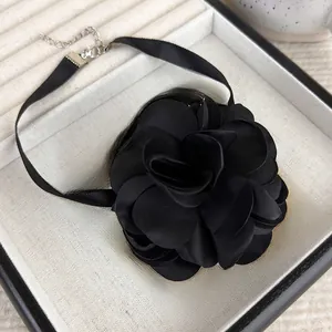 Close-up of a black satin rose choker with adjustable metal lobster clasp and chain