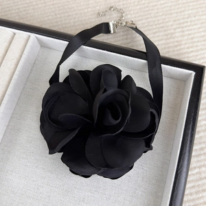 Detail view of large black satin rose choker with silver metal adjustable chain links