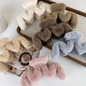 Pinces à cheveux en peluche ondulées aux tons pastels sur un plateau en bois élégant