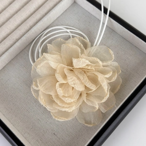 Vue macro d'une grande fleur de camélia en tissu champagne avec pétales scintillants