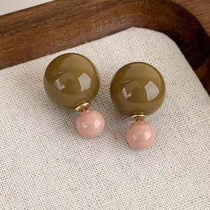 Dettaglio di orecchini vintage francesi con doppia perla bicolore verde oliva e rosa cipria