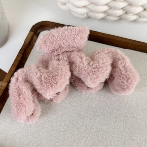 Détail de la pince à cheveux ondulée en peluche rose avec fausse fourrure douce