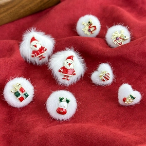 Christmas earrings featuring white fur balls and festive charms on red velvet backdrop