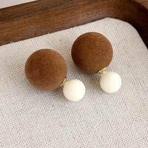 Dettaglio di orecchini vintage floccati marroni e crema con dettagli in metallo dorato