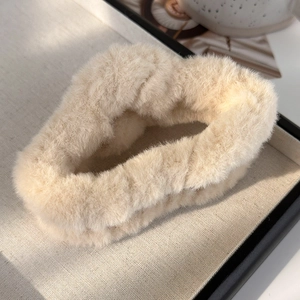 Gros plan sur la pince à cheveux en peluche blanc cassé à la texture douce