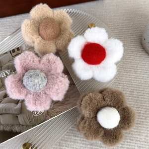 Pinces à cheveux en peluche en forme de fleur de diverses couleurs sur un plateau élégant